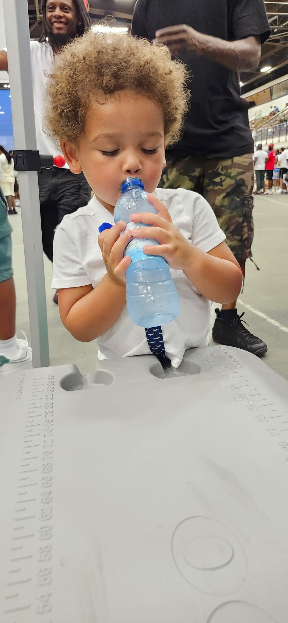 A child drinking Eleven86 water at a Heko community event